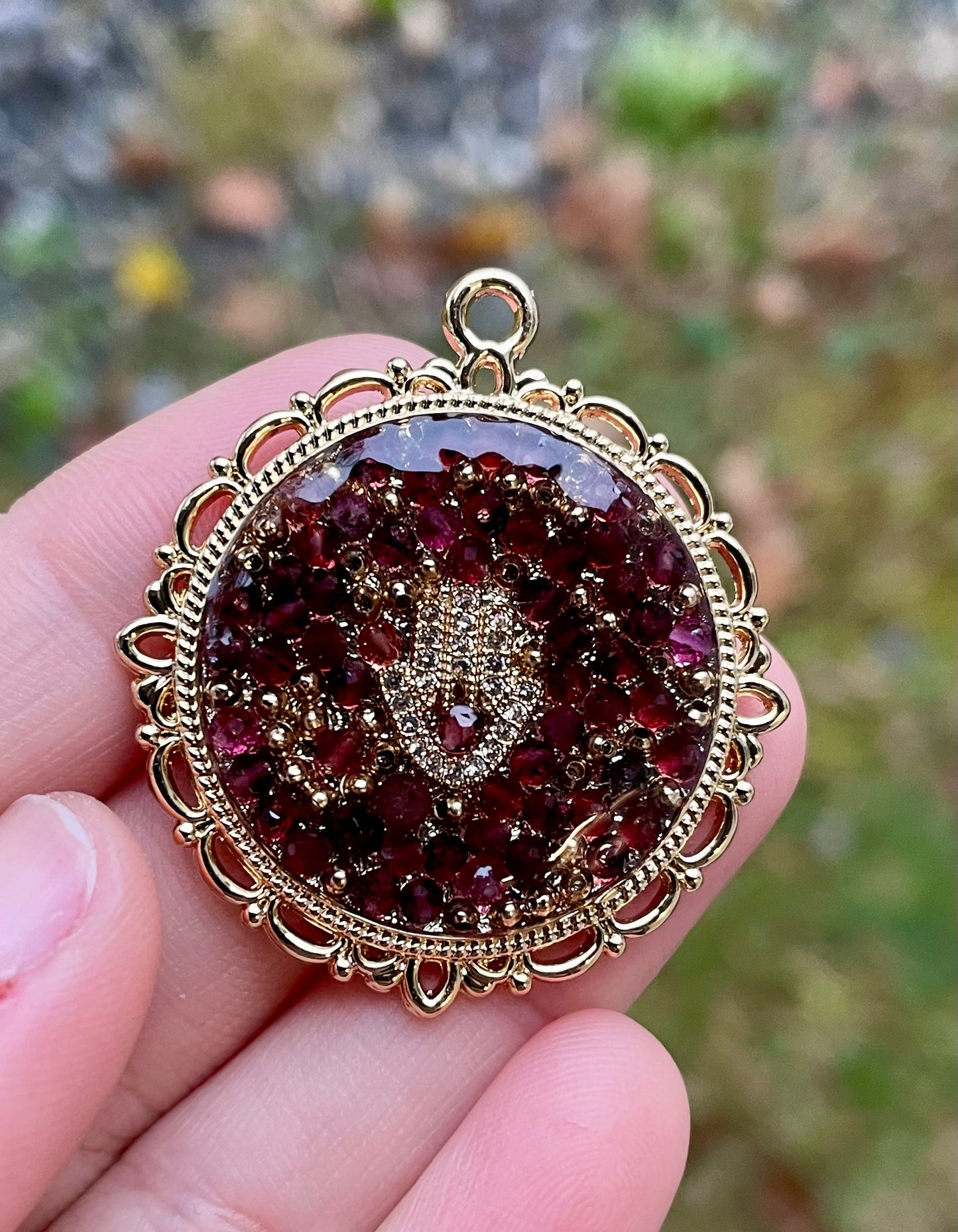 Anava: Garnet Gemstones Gold Plated Hamsa Round Decorated Resin Pendant