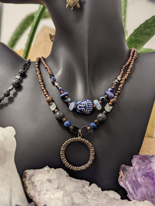 Tribal Layers: Blue Gemstone Tribal Mask Shaped Pendant and Round Metallic Tribal Metallic Pendant, Turtle Earrings and Grey Gem Bracelet