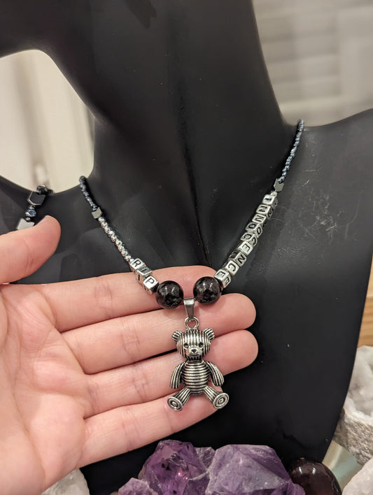 Dark Humor Series (1): Silver Teddy Bear Pendant with RIP INNOCENCE silver acrylic letters, Garnet Gemstones and glass beads