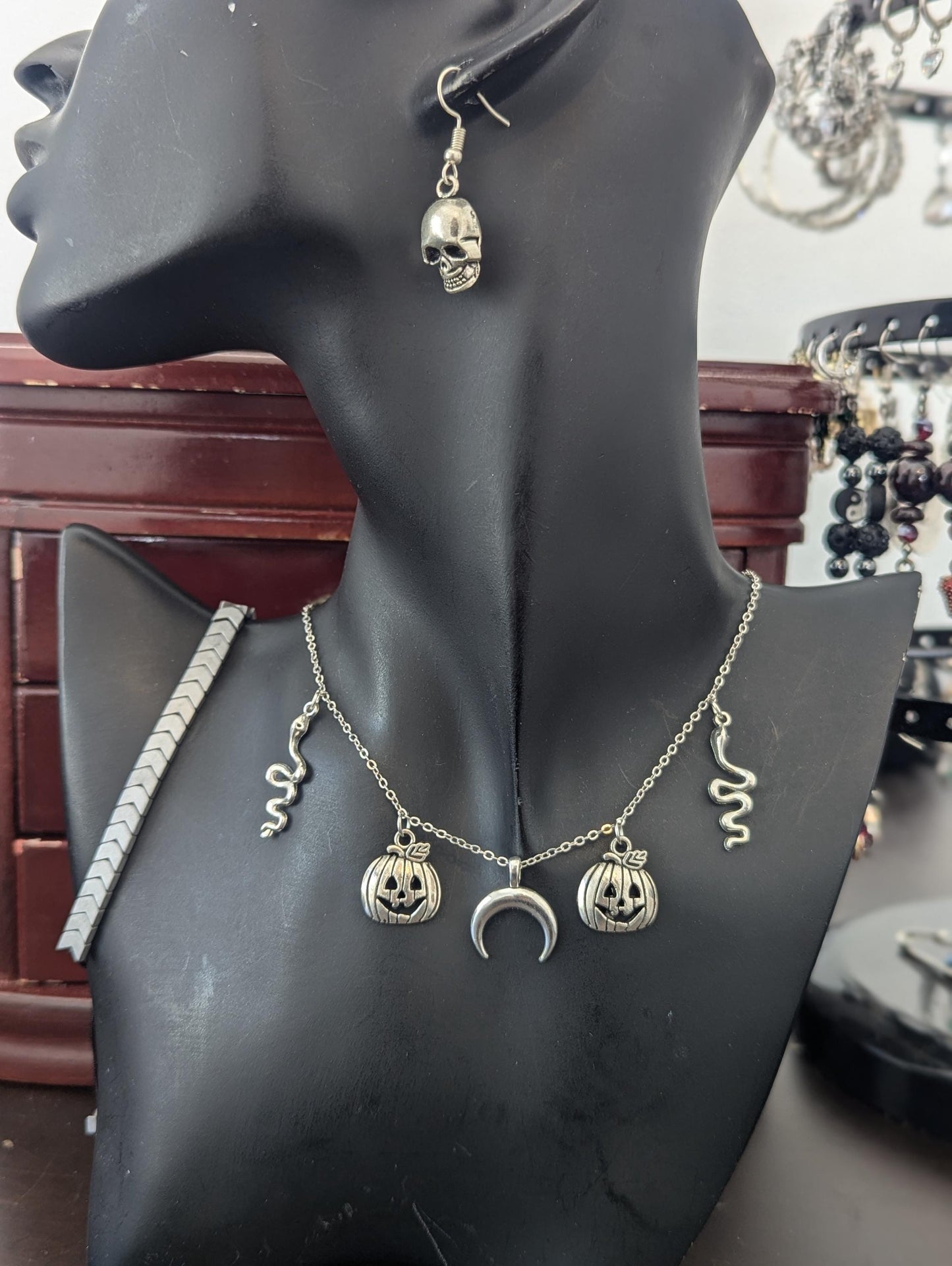 Silver Halloween Set. Made with silver snake, moon and jack-o'-lantern pendants on a silvery chain, silver grey bracelet and skull earrings