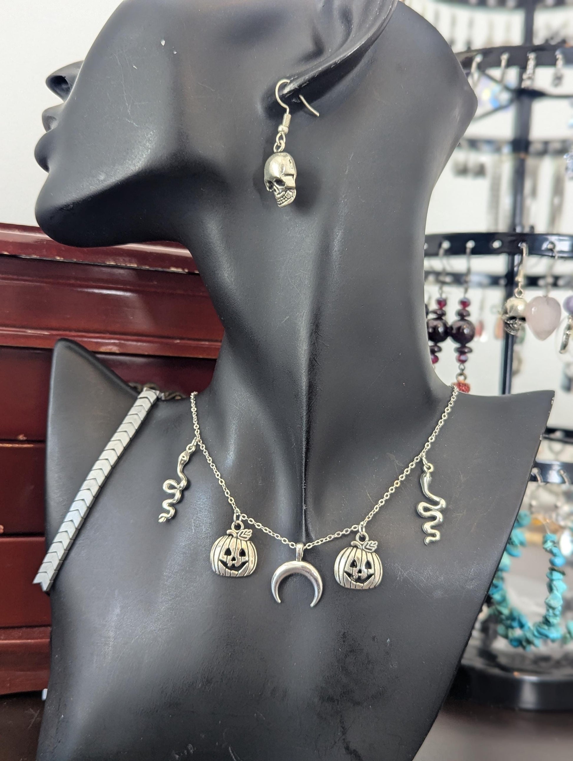 Silver Halloween Set. Made with silver snake, moon and jack-o'-lantern pendants on a silvery chain, silver grey bracelet and skull earrings