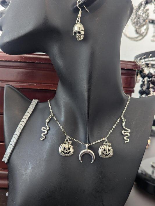 Silver Halloween Set. Made with silver snake, moon and jack-o'-lantern pendants on a silvery chain, silver grey bracelet and skull earrings